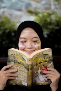 woman covering her face with book